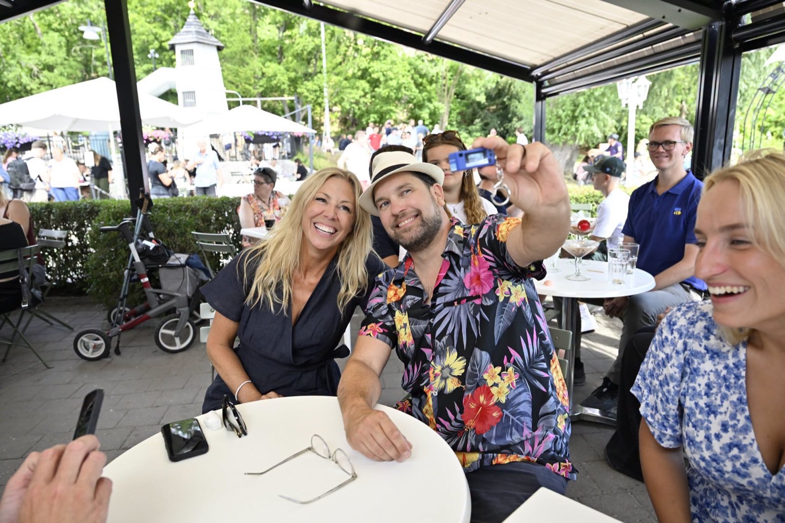 Linda Lindberg fotograferas tillsammans med Jimmie Åkesson på en uteservering under sommarkampanjen.